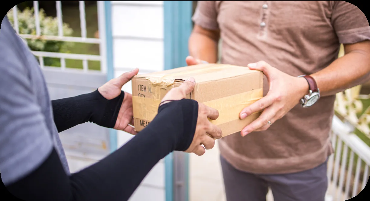 A parcel being handed from a courier to a customer