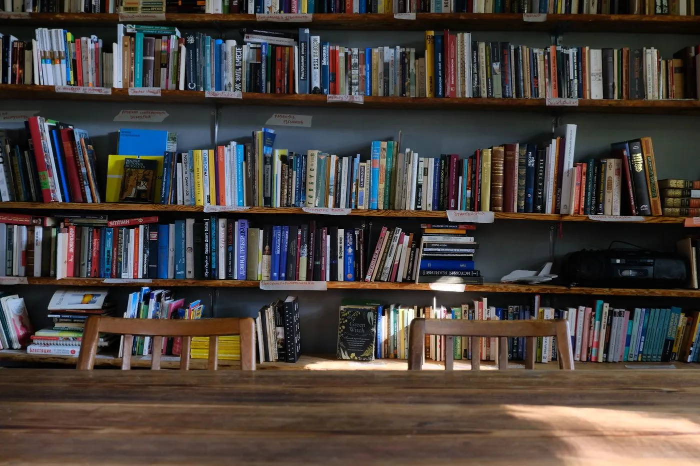 Sunlit study tables in front of library shelves filled with books